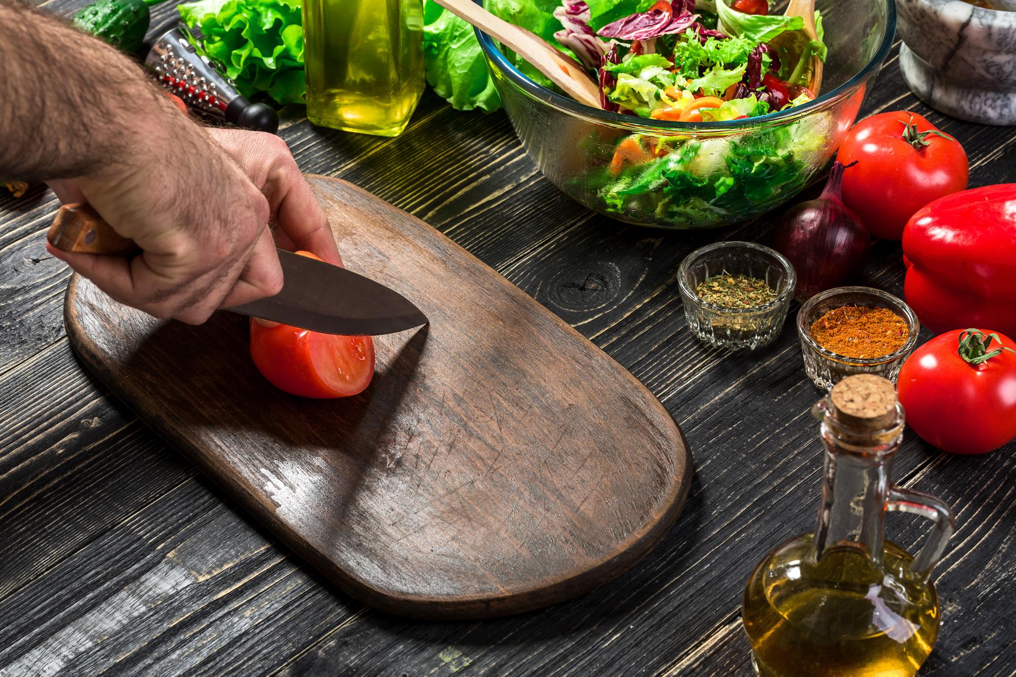 Local chef slicing vegetables on wooden board